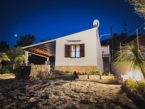 A modern house with a stone facade, a covered porch, and a satellite dish.