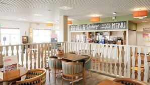 A restaurant with a 'REFUEL & Recharge' sign, wooden tables and chairs, and a white railing. - 3 bedroom accommodation in Heysham, near Lancaster (Heysham, near Lancaster)