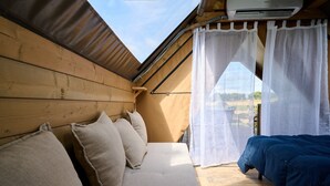 Une pièce en bois avec un lit, un canapé et une fenêtre avec des rideaux.