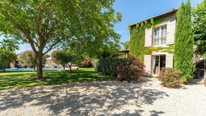 A house with a swimming pool, surrounded by a well-maintained garden and a gravel driveway. - Country House 'Le Mas' with Shared Pool, Wi-Fi, and Air Conditioning (Graveson)