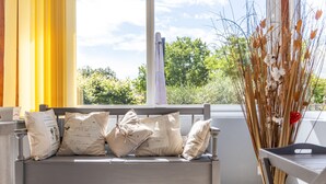 A balcony with a white bench, beige cushions with handwritten notes, and a vase with dried plants. - The Calm of Périgord Noir – Comfortable House near Sarlat-la-Canéda (Carsac-Aillac)