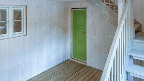 A narrow hallway with white wooden walls, a green door, and a wooden staircase. - 2 bedroom beautiful home in Feda (Feda)
