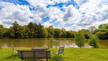 A park with a lake, benches, and trees.