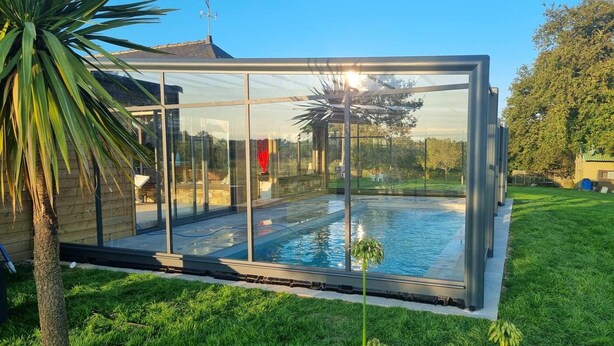 Una piscina moderna, rodeada de vidrio, con vistas despejadas del paisaje circundante.