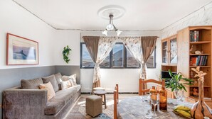 A living room with a sofa, dining table, chairs, and a bookshelf. - Holiday Apartment 'Siempreviva' with Shared Pool and Wi-Fi (Gáldar)