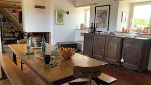 Une cuisine avec une table en bois, un banc et un poêle rustique.