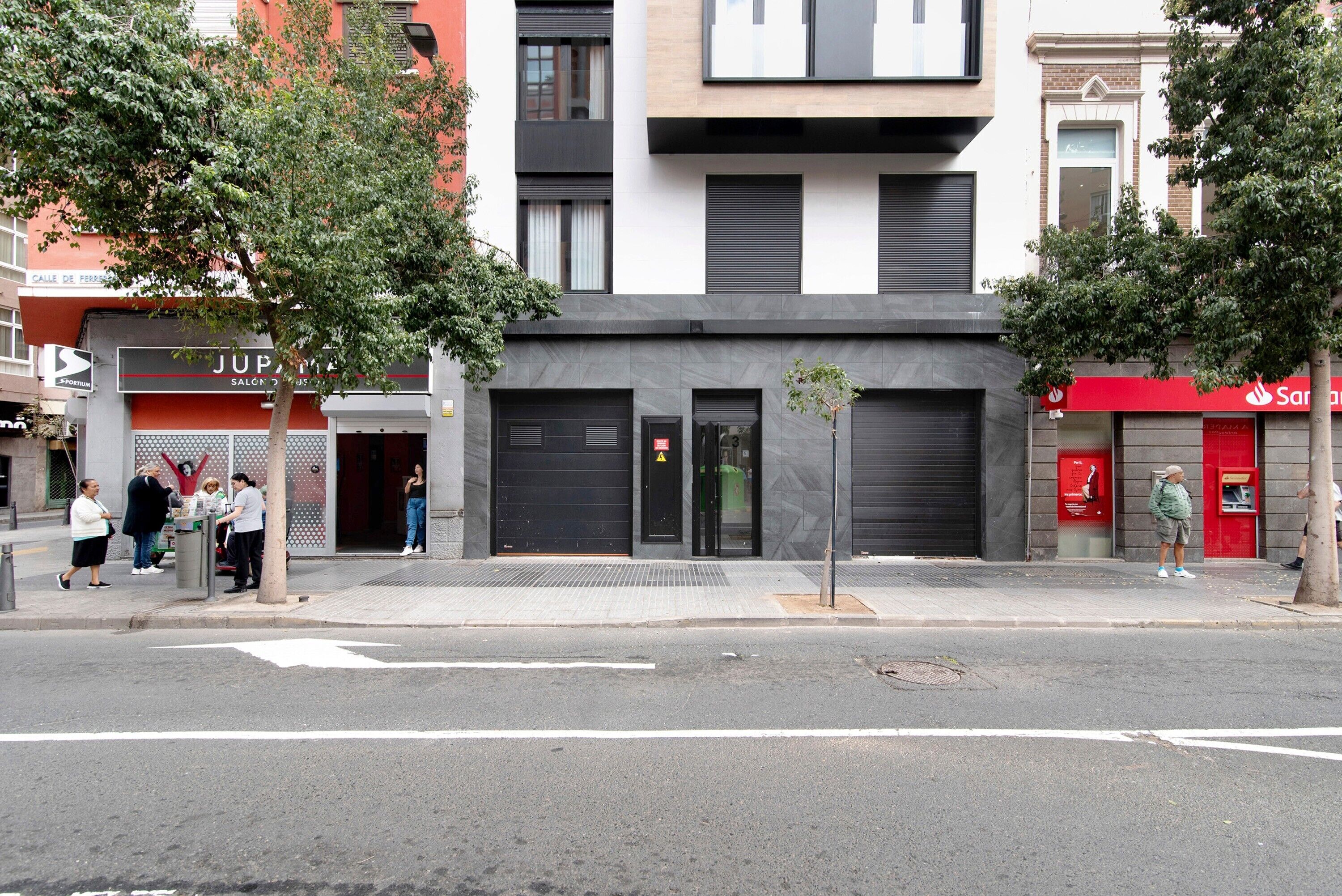 Un edificio moderno con escaparate, entrada visible y acera.