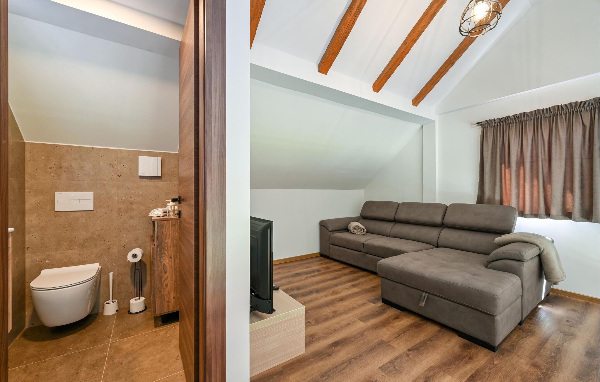 Ein modernes Wohnzimmer mit einem Ecksofa, einem Flachbildfernseher und einer Holzzieldecke.