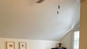A bedroom with a large bed, a nightstand, a dresser, and two framed pictures on the wall. - The Birch at Lazy Oaks Resort (duplex) (Lakeside)