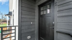 A dark wooden door with a mailbox and a small window above it.