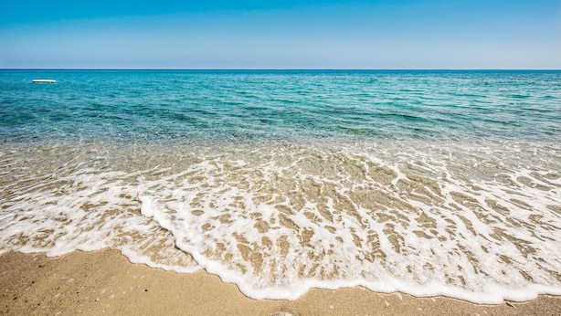 Une plage à l’eau claire et au rivage sablonneux.