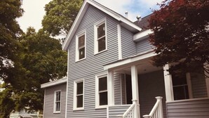 A two-story house with a porch and a staircase.
