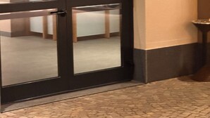 A door with frosted glass panels, a tiled floor, and a small table beside the door.