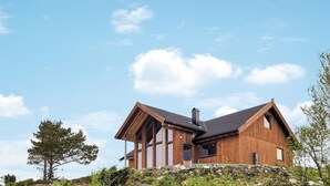 A modern wooden cabin with a sloped roof, large windows, and a stone foundation. - 4 bedroom cozy home in Sveio (Sveio)