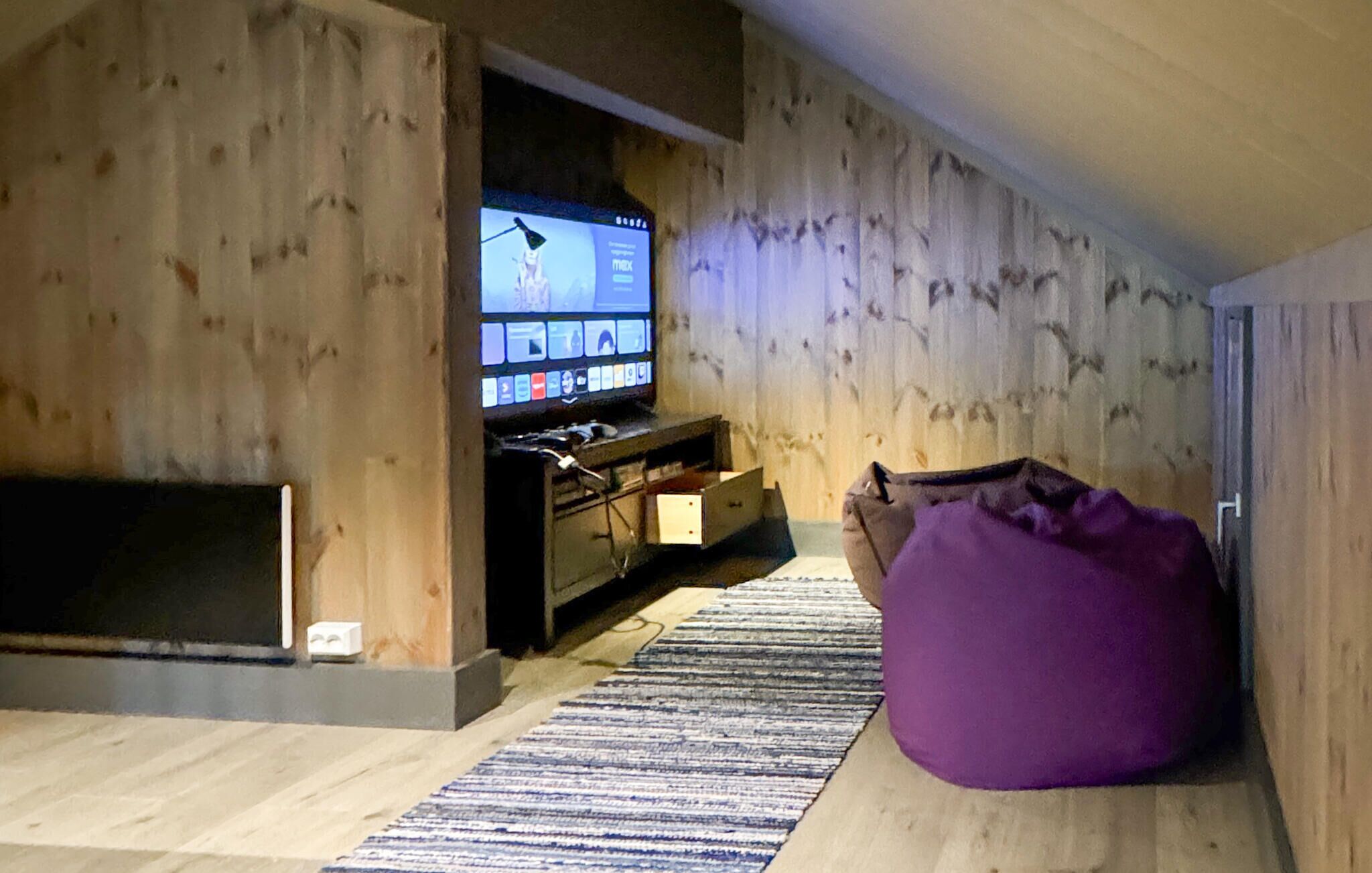 Un salón acogedor con detalles de madera, un televisor, un sofá y una chimenea.