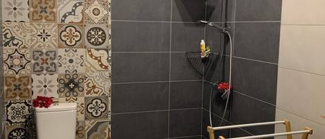 Un baño con ducha, inodoro y lavamanos.