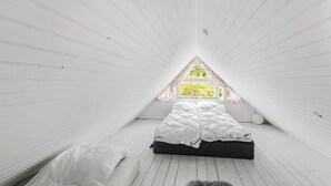 A small attic bedroom with a sloped ceiling, a single bed, and a window with a view of greenery. - Beautiful home in Hemmet with WiFi (Hemmet)