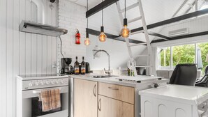 A modern kitchen with a white stove, wooden cabinets, and pendant lights. - Beautiful home in Hemmet with WiFi (Hemmet)