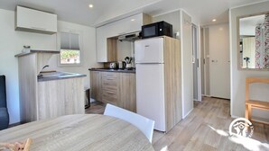 Una cocina compacta equipada con microondas, tostadora y refrigerador.