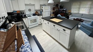 Una cocina moderna con armarios blancos, una isla central e iluminación colgante.