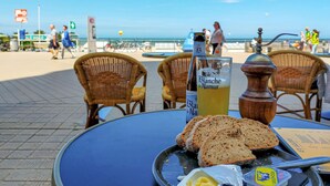 Una mesa con una botella de Blanche de Narmer, rebanadas de pan y un cuenco de mantequilla.