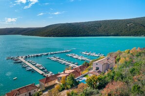 A marina with boats docked, a pier extending into the water, and buildings with red-tiled roofs. - Villa Mia (Istria - Trget) (Trget)