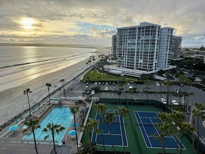 Ett hotell vid stranden med en swimmingpool, tennisbanor och utsikt över havet.
