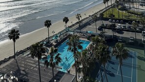 Een strandhotel met zwembad, toegang tot het strand en uitzicht op de oceaan.