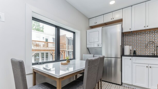 A modern kitchen with white cabinets, a stainless steel refrigerator, and a patterned backsplash. - @StayatNoMA (Washington)