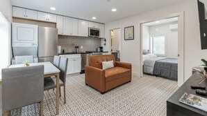 A compact living space with a kitchenette, a dining area, a sofa, and a bedroom. - @StayatNoMA (Washington)