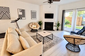 A modern living room with a sofa, armchair, coffee table, and a fireplace. - Top-Rated ILM Oasis: Spacious, Pet-Friendly, Pool! (Wilmington)