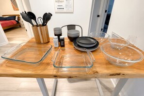 A dining table with glassware, plates, and a wooden cutting board. - Top-Rated ILM Oasis: Spacious, Pet-Friendly, Pool! (Wilmington)