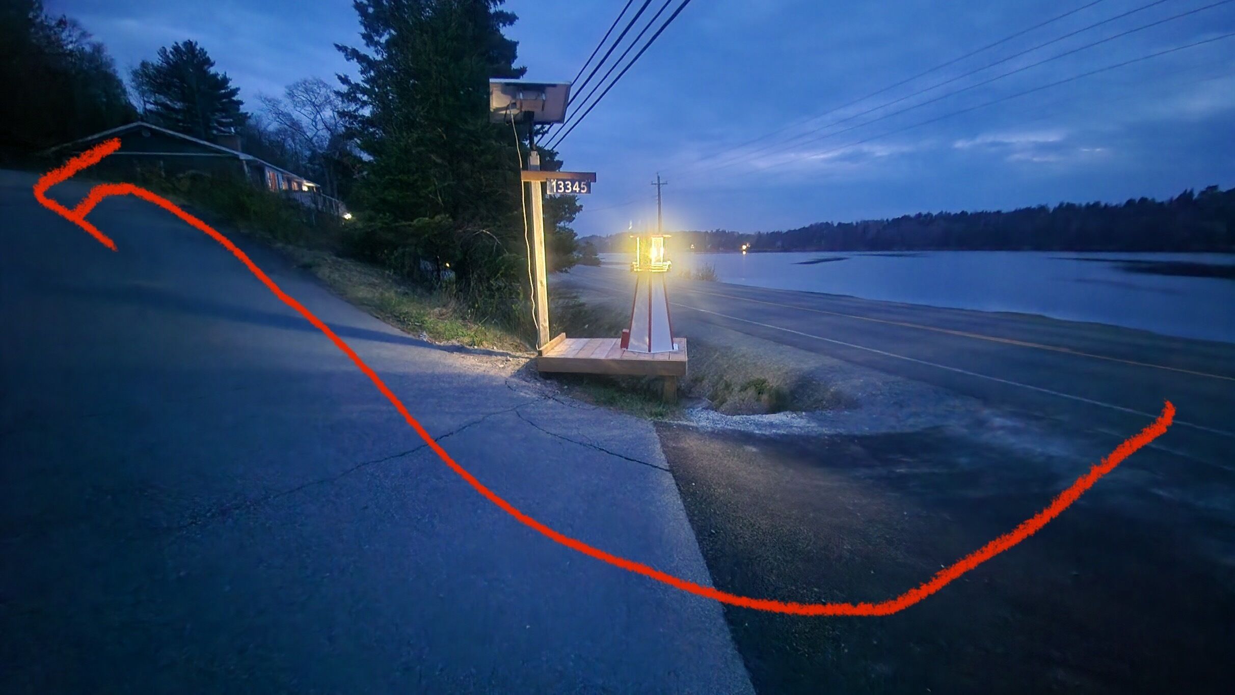 A road with a wooden structure and a street sign.