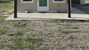 A single-story house with a gabled roof, a front door, and two windows. - Tiny house hideaway just outside of town (Cody)