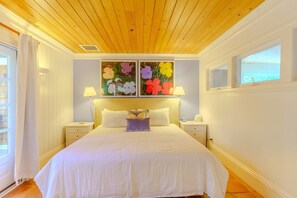 Cozy retreat with a large bed, bedside tables, and a window offering a view of the outside.