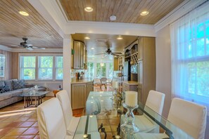 Relax in this stylish living area with a glass dining table, modern cabinetry, and ample workspace.