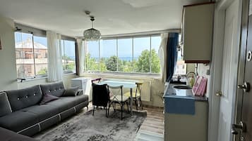 Apartamento luxo, cozinha, vista para o mar | Área de estar | Smart TV 27 polegadas com canais digitais, Netflix