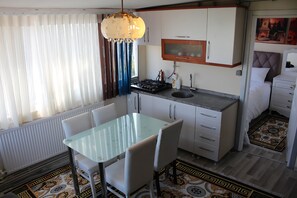 Deluxe appartement, keuken, uitzicht op zee | Privékeuken | Een mini-koelkast, een kookplaat, kookgerei, borden en bestek