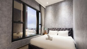 Ein modernes Schlafzimmer mit einem großen Bett, Blick durch ein Fenster und einer Stadtansicht.
