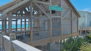 A wooden beach house named 'Emerald Shores' with a balcony overlooking the ocean. - Pet & Family Friendly, Walk or Tram 2 Private Beach Access Pavilion, Pools, Tennis - Emerald Shores (Miramar Beach)