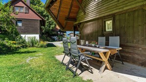 Une maison en bois dotée d’un coin repas comprenant une table et des chaises en bois.