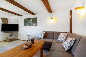 A living room with a sofa, wooden coffee table, and a flat-screen TV.