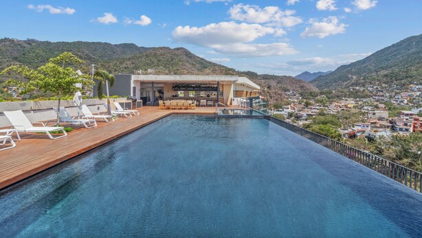 Ein Pool mit Liegestühlen und ein Gebäude mit einer Terrasse.
