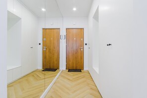 Stylish hallway with modern doors and herringbone-patterned flooring.