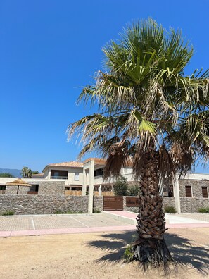 Stunning residential property with a stone facade and tiled roof, set amidst lush surroundings.