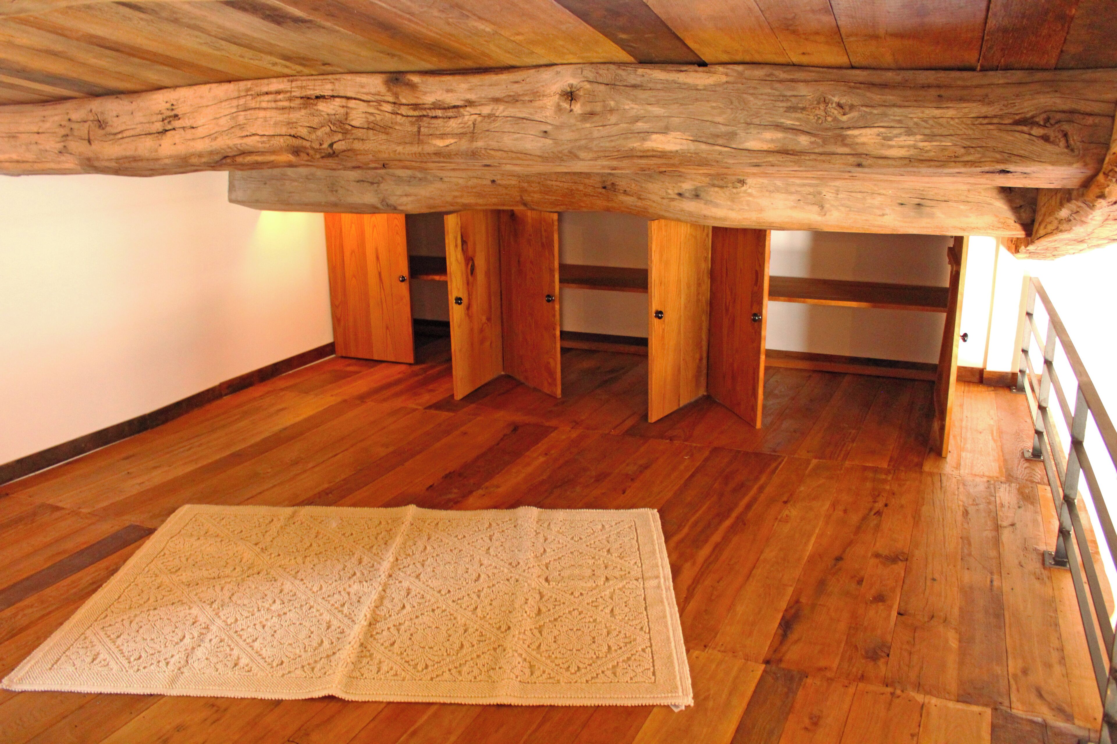 A wooden floor with a large, open space beneath a wooden beam.