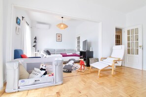 Relax in this spacious living area with a comfortable seating area, play space, and large window.