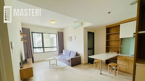 Un appartement moderne comprenant un espace de vie, une table à manger et une kitchenette.