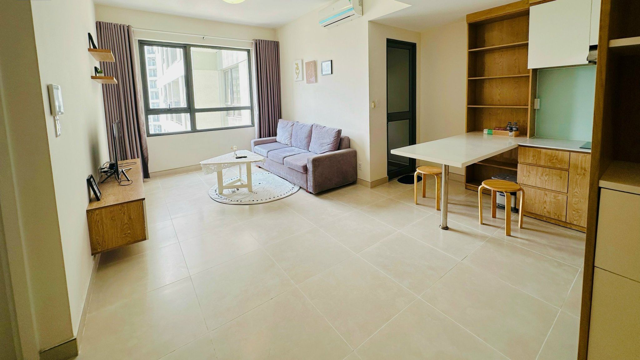 A modern apartment with a living area, a dining table, and a kitchenette.