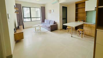 A modern apartment with a living area, a dining table, and a kitchenette.